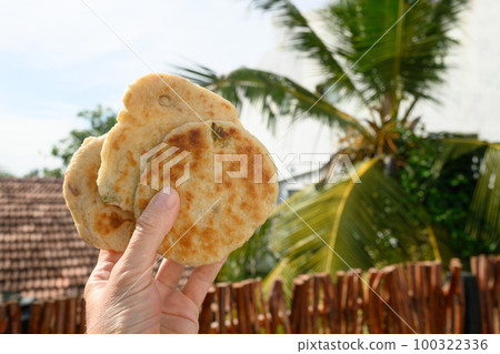Authentic Sri Lankan three Pol Coconut Roti iin hand. 100322336