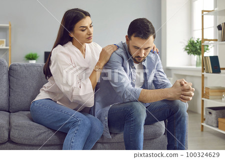 Young woman trying to make peace with husband after quarrel sitting on sofa at home. Young woman trying to make peace with husband after quarrel sitting on sofa at home. 100324629