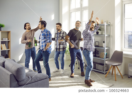 Happy male friends having party, dancing and drinking beer, having fun together at home. Happy male friends having party, dancing and drinking beer, having fun together at home. 100324663