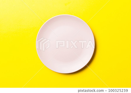 Top view of isolated of colored background empty round pink plate for food. Empty dish with space for your design Top view of isolated of colored background empty round pink plate for food. Empty dish with space for your design 100325239