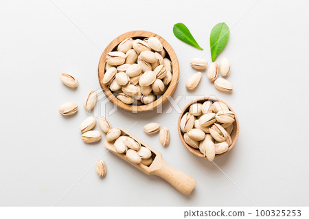 Fresh healthy Pistachios in bowl on colored table background. Top view Healthy eating concept. Super foods Fresh healthy Pistachios in bowl on colored table background. Top view Healthy eating concept. Super foods 100325253