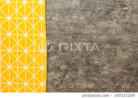 top view with yellow empty kitchen napkin isolated on table background. Folded cloth for mockup with copy space, Flat lay. Minimal style top view with yellow empty kitchen napkin isolated on table background. Folded cloth for mockup with copy space, Flat lay. Minimal style 100325289