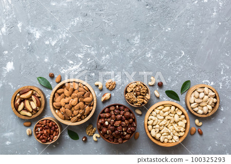 mixed nuts in wooden bowl. Mix of various nuts on colored background. pistachios, cashews, walnuts, hazelnuts, peanuts and brazil nuts mixed nuts in wooden bowl. Mix of various nuts on colored background. pistachios, cashews, walnuts, hazelnuts, peanuts and brazil nuts 100325293