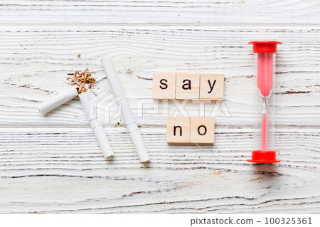 Cigarette And Wooden Blocks, Broken cigarette on table background with hourglass, No Tobacco Day with hourglass, clock health concept. time to quit smoking 100325361