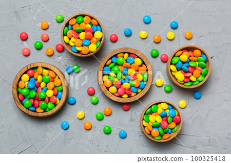 different colored round candy in bowl and jars. Top view of large variety sweets and candies with copy space 100325418