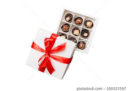 Chocolate candy in a box with a colored bow. Gift box with Chocolates isolated on white top view 100325597