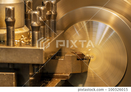 Closeup scene the lathe machine finish cut the brass parts by lathe tools. Closeup scene the lathe machine finish cut the brass parts by lathe tools. 100326015