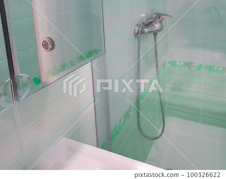 Bathroom with shower with glass partition, faucet in the background Bathroom with shower with glass partition, faucet in the background 100326622