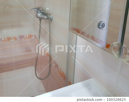 Bathroom with shower with glass partition, faucet in the background Bathroom with shower with glass partition, faucet in the background 100326625