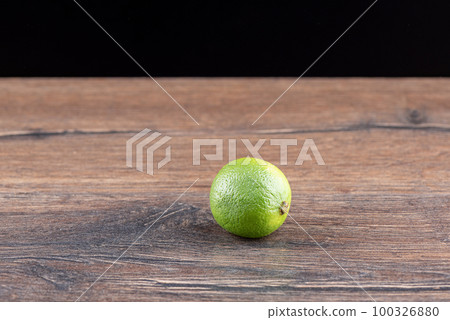 Whole fresh lime on wooden background with place for text. 100326880