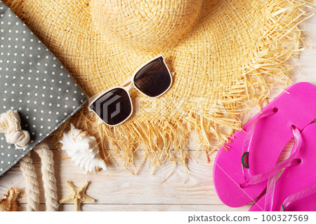 Straw hat sunglasses flip flops and beach bag on white wooden background Straw hat sunglasses flip flops and beach bag on white wooden background 100327569