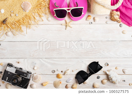 Camera straw hat sunglasses flip flops on white wooden background Camera straw hat sunglasses flip flops on white wooden background 100327575
