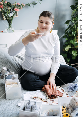 How To Start A Pregnancy Baby Blog for parents-to-be and make money from home. Pregnant woman blogger recording video for her blog social media. 100327793