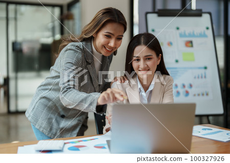Financial analysts analyzing business reports on planned investment projects during corporate meeting discussions showcase successful teamwork with marketing plan, computers and calculators to work. 100327926