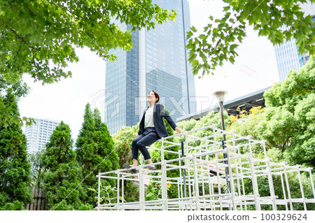 A woman climbing a jungle gym Fresh green 100329624