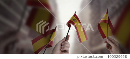 A group of people holding small flags of the Spain in their hands 100329638