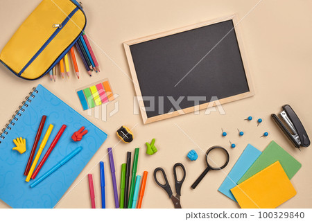 Flat lay photo of workspace desk with school accessories or office supplies on pink background. Flat lay photo of workspace desk with school accessories or office supplies on pink background. 100329840