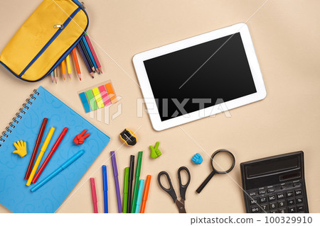 Flat lay photo of workspace desk with school accessories or office supplies. 100329910