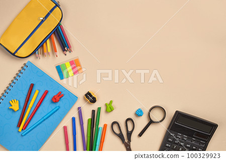 Flat lay photo of workspace desk with school accessories or office supplies on pink background. Flat lay photo of workspace desk with school accessories or office supplies on pink background. 100329923
