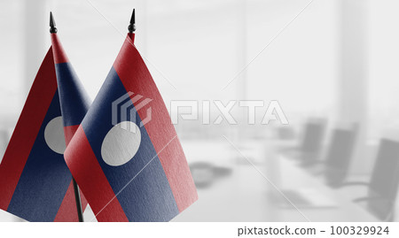 Small flags of the Laos on an abstract blurry background Small flags of the Laos on an abstract blurry background 100329924