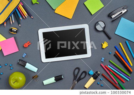 Flat lay photo of workspace desk with school accessories or office supplies on gray background. Flat lay photo of workspace desk with school accessories or office supplies on gray background. 100330074