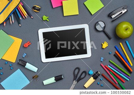 Flat lay photo of workspace desk with school accessories or office supplies on gray background. 100330082
