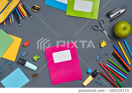 Flat lay photo of workspace desk with school accessories or office supplies on gray background. 100330133
