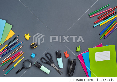 Flat lay photo of workspace desk with school accessories or office supplies on gray background. 100330310