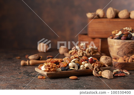 Mix of nuts and raisins on a brown rustic background. Mix of nuts and raisins on a brown rustic background. 100330400