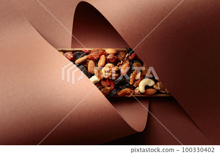 The mix of dried fruits and berries on a brown background. 100330402