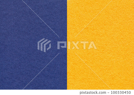 Texture of craft navy blue and yellow paper background, half two colors, macro. Vintage dense denim cardboard 100330450