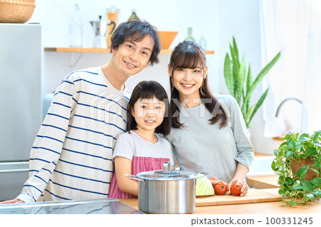 A family of three cooking together in the kitchen A family of three cooking together in the kitchen 100331245