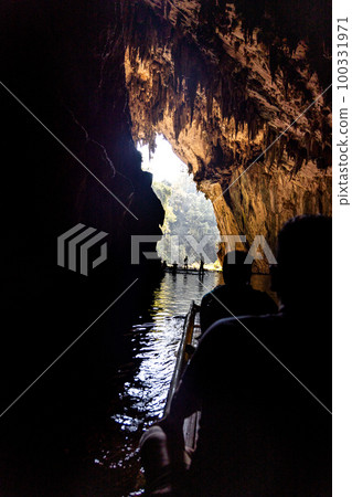 Tourists in silhouette ferried on bamboo rafts inside the tunnel river within Tham Nam Lod caves, Mae Hong Son province, Thailand. Tourists in silhouette ferried on bamboo rafts inside the tunnel river within Tham Nam Lod caves, Mae Hong Son province, Thailand. 100331971