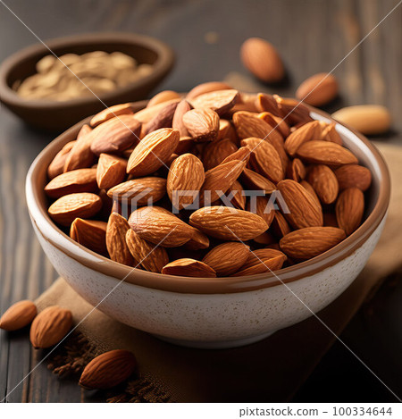 Almonds in a ceramic bowl on a wooden background. Almonds in a ceramic bowl on a wooden background. 100334644