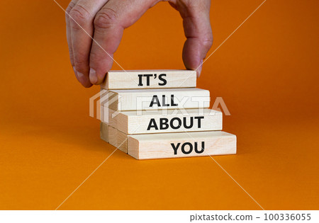 It is all about you symbol. Wooden blocks with words 'It is all about you'. Beautiful orange background. Businessman hand. Copy space. Business and it is all about you concept. It is all about you symbol. Wooden blocks with words 'It is all about you'. Beautiful orange background. Businessman hand. Copy space. Business and it is all about you concept. 100336055