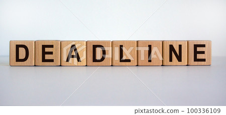 Concept word 'deadline' on wooden cubes on a beautiful wooden table. White background. Business concept. Concept word 'deadline' on wooden cubes on a beautiful wooden table. White background. Business concept. 100336109