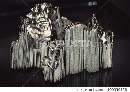 Object printed on metal 3d printer close-up. Object printed in laser sintering machine. Modern 3D printer printing from metal powder. Concept progressive additive DMLS, SLM, SLS 3d printing technology Object printed on metal 3d printer close-up. Object printed in laser sintering machine. Modern 3D printer printing from metal powder. Concept progressive additive DMLS, SLM, SLS 3d printing technology 100336158