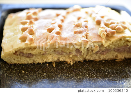 Sliced meat pie made of dough close-up. Pieces of butter cake. 100336240