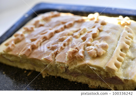 Sliced meat pie made of dough close-up. Pieces of butter cake. 100336242