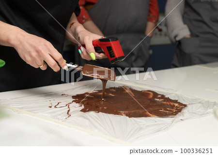 Tempering dark chocolate. pyrometer to measure the temperature of chocolate Tempering dark chocolate. pyrometer to measure the temperature of chocolate 100336251
