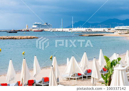 Private beach on Croisette and cruise ship in distance in summer Private beach on Croisette and cruise ship in distance in summer 100337142