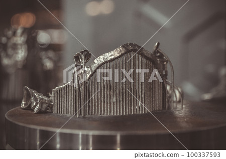 Object printed on metal 3d printer close-up. Object printed in laser sintering machine. Modern 3D printer printing from metal powder. Concept progressive additive DMLS, SLM, SLS 3d printing technology Object printed on metal 3d printer close-up. Object printed in laser sintering machine. Modern 3D printer printing from metal powder. Concept progressive additive DMLS, SLM, SLS 3d printing technology 100337593