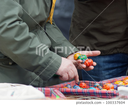 Tourist buying painted ester eggs at Prague farmers street market. 100337604