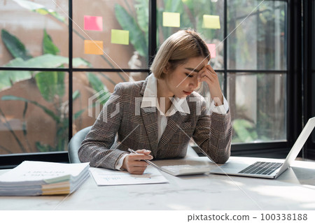 young asian businesswoman Stressing thoughts on work or headache documents at the desk in the office young asian businesswoman Stressing thoughts on work or headache documents at the desk in the office 100338188