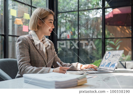 Business woman calculating monthly expenses, managing budget. Woman sitting at table using calculator to calculate tax refund, working at office with laptop on table Business woman calculating monthly expenses, managing budget. Woman sitting at table using calculator to calculate tax refund, working at office with laptop on table 100338190