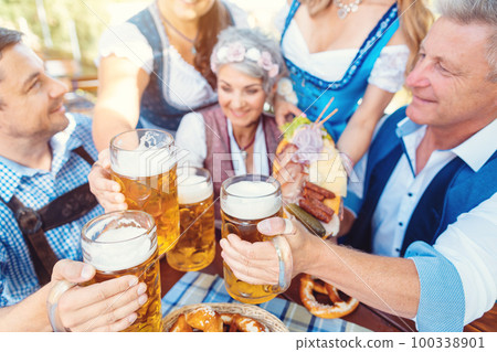 Group of friends toasting in beer garden Group of friends toasting in beer garden 100338901