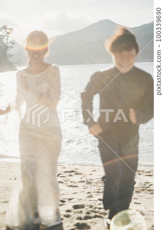 新娘和新郎在沙灘上奔跑 新娘和新郎在沙灘上奔跑 100339690