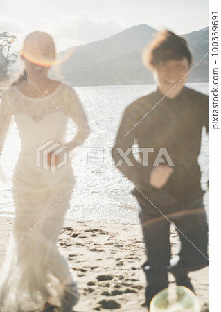 新娘和新郎在沙灘上奔跑 新娘和新郎在沙灘上奔跑 100339691