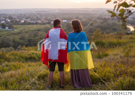 Couple covered in Ukraine and Switzerland flags Couple covered in Ukraine and Switzerland flags 100341179