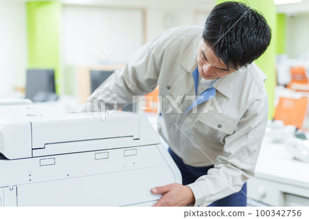 Worker who inspects copy machine Worker who inspects copy machine 100342756
